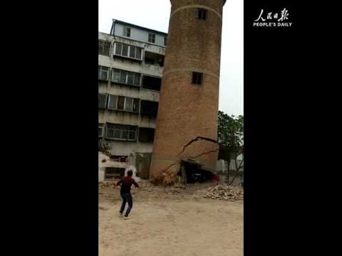 لحظة انهيار مدخنة ضخمة فوق عامل